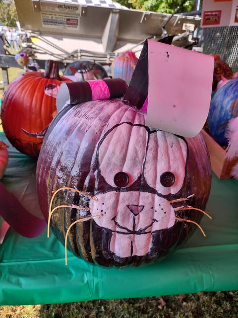 Painted pumpkin decorated as a rabbit: button eyes, paper ears, and straw whiskers