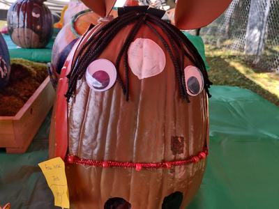 Decorated pumpkin with googly eyes, yarn hair, cardboard ears and two small painted pumpkins