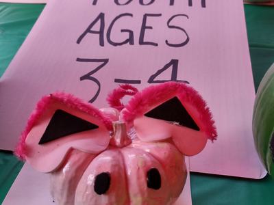 Painted small pumpkin with pink ears and black eyes; sign reading "YOUTH AGES 3-4"
