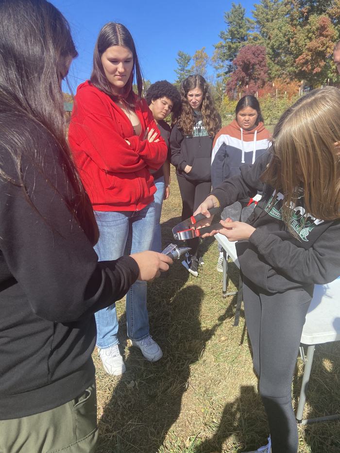 Two girls work together in a field.
