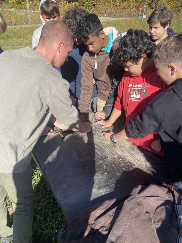 Kids inspect soil on a table.