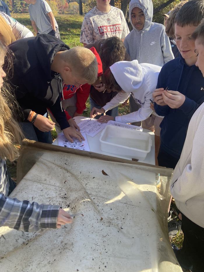 Kids stand at a table.