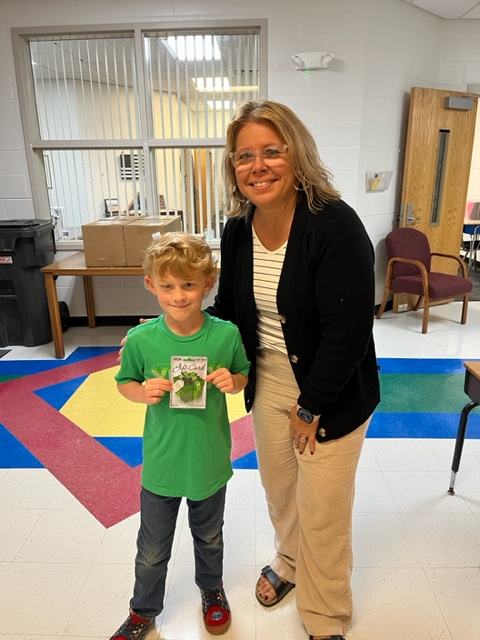 School Principal pictured with student who estimated the closest weight of the giant pumpkin