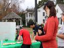 Students at outdoor table with poster titled "Cyberbullying & Bullying"