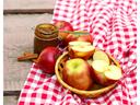 bowl of apples, jar of apple butter on a red and white gingham tablecloth