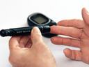 person testing glucose with finger stick