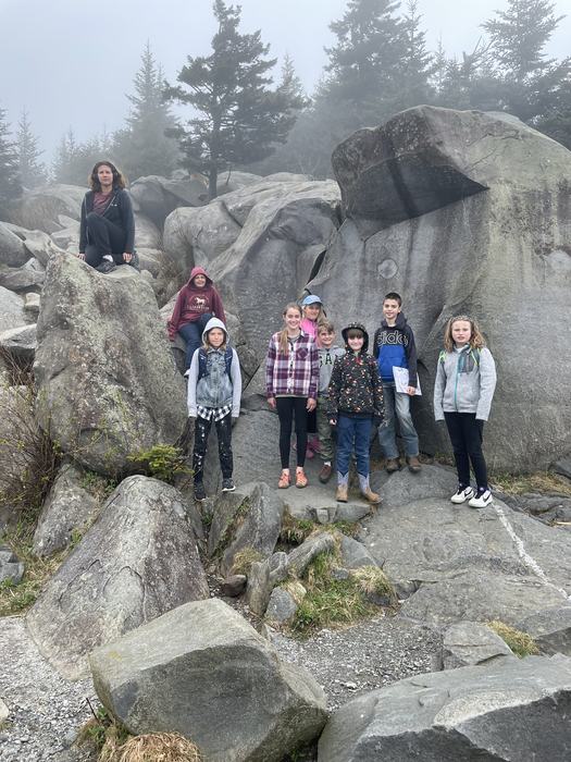 Children pose in a rock garden.