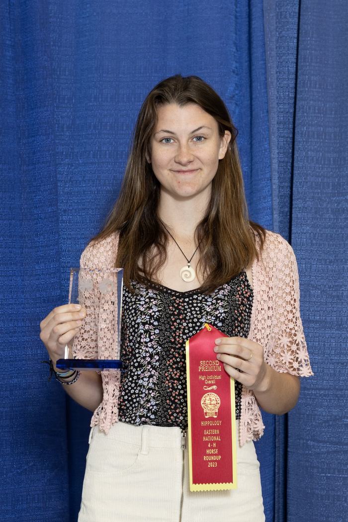 Woman holding trophy and ribbon reading "SECOND PREMIUM" and "4‑H Horse Roundup 2023"