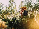 A girl in hat and scarf holding a cut Christmas tree