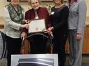 A woman is presented with a plaque for the Surry County Agricultural Hall of Fame.