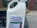 White pesticide bottle on truck tailgate.