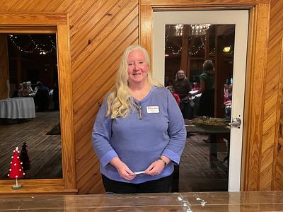 Woman standing behind a wooden counter in a lodge room wearing a name tag