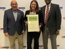 Three people standing; center woman holds "Eat Smart Move More" North Carolina award certificate