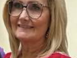 Blonde woman wearing glasses and a red blouse, facing the camera