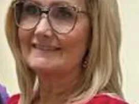 Blonde woman wearing glasses and a red blouse, facing the camera