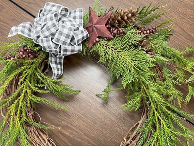 Completed wreath with an evergreen branch and ribbon.