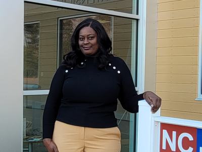 A woman stands outside of an N.C. Cooperative Extension office.