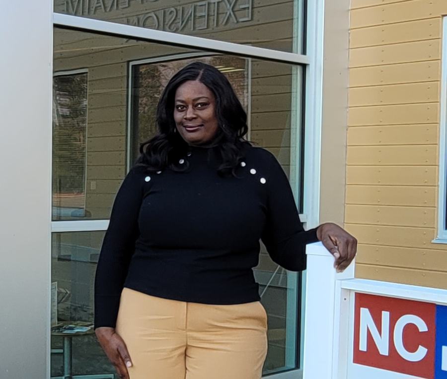 A woman stands outside of an N.C. Cooperative Extension office.