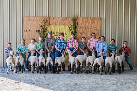 youth livestock group photo. 12 youth stand with their show sheep. 