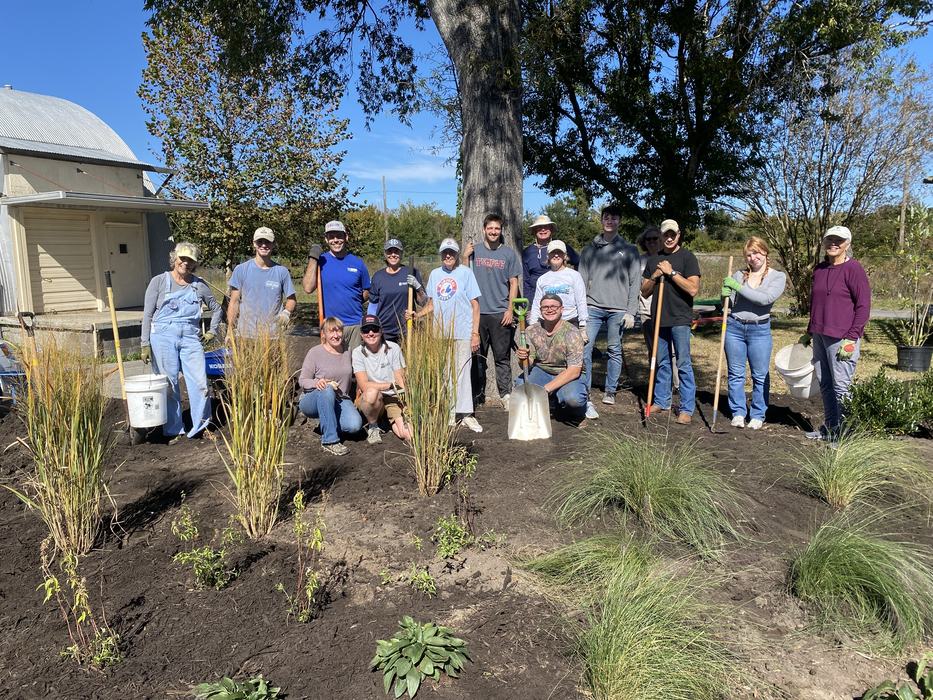 volunteers standing beside a native plant bed installation