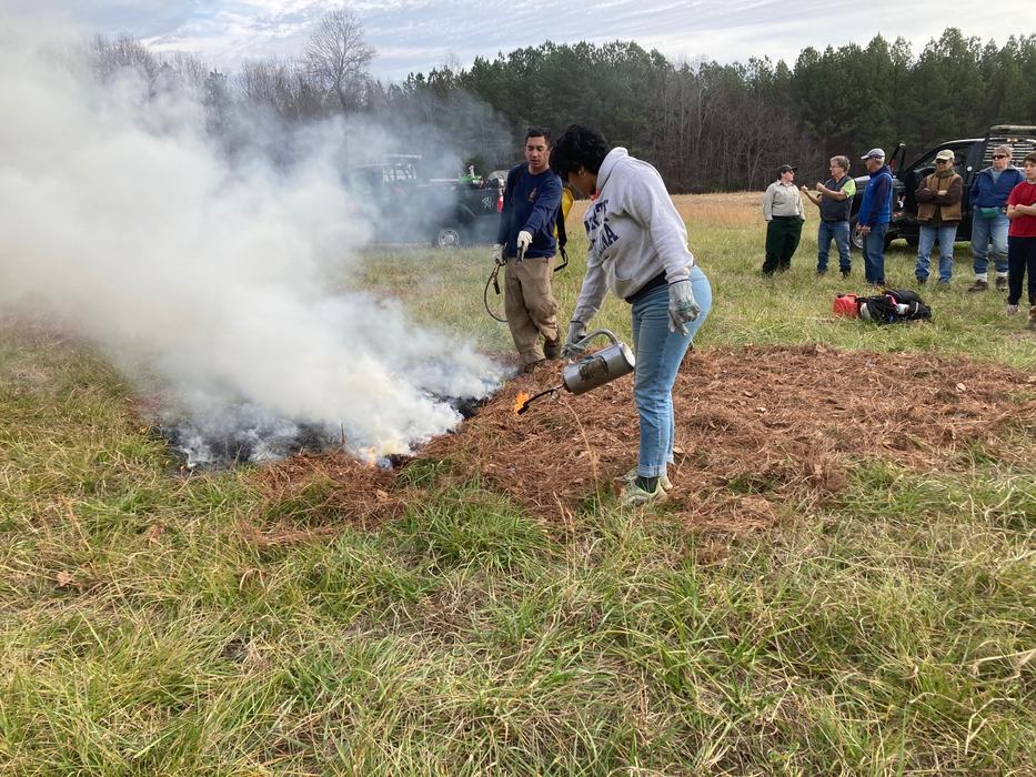 A person uses a prescribed fire tool