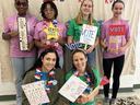 A group of girls hold signs encouraging others to vote.
