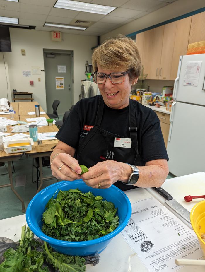  EMFV Lori Van Horn from Ocean Isle Beach adding the arugula to the kale for the salad