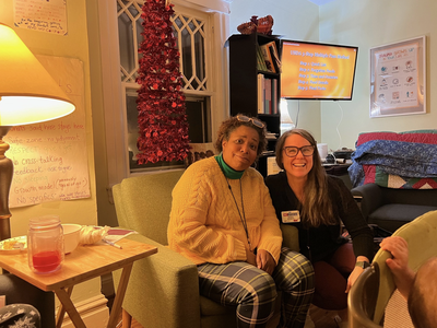 Two women in a cosily lit room.