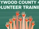 Haywood County 4-H Volunteer Training in white with hands of different skin tones raised holding red hearts. On green streaky background