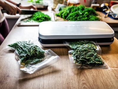 Vacuuming dill. Vacuum packing machine on the table