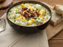 Bowl of potato soup with cheddar and bacon on top