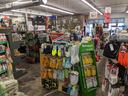 Hardware store aisle with multiple glove displays and gardening supplies