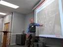 A man teaches a class using a projector.