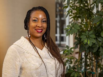 A professional image of a woman in front of foliage.