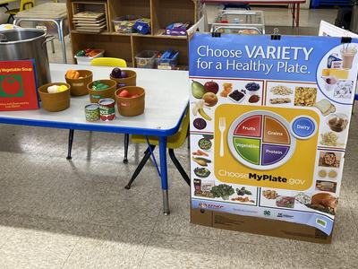 the book "Growing Vegetable Soup" set up with fake vegetables on table for kids.