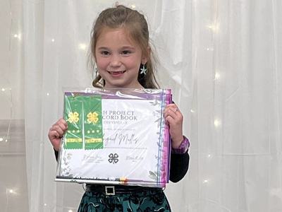 Abbigail Mullis receiving her award for submitting two Cloverbud Record Books