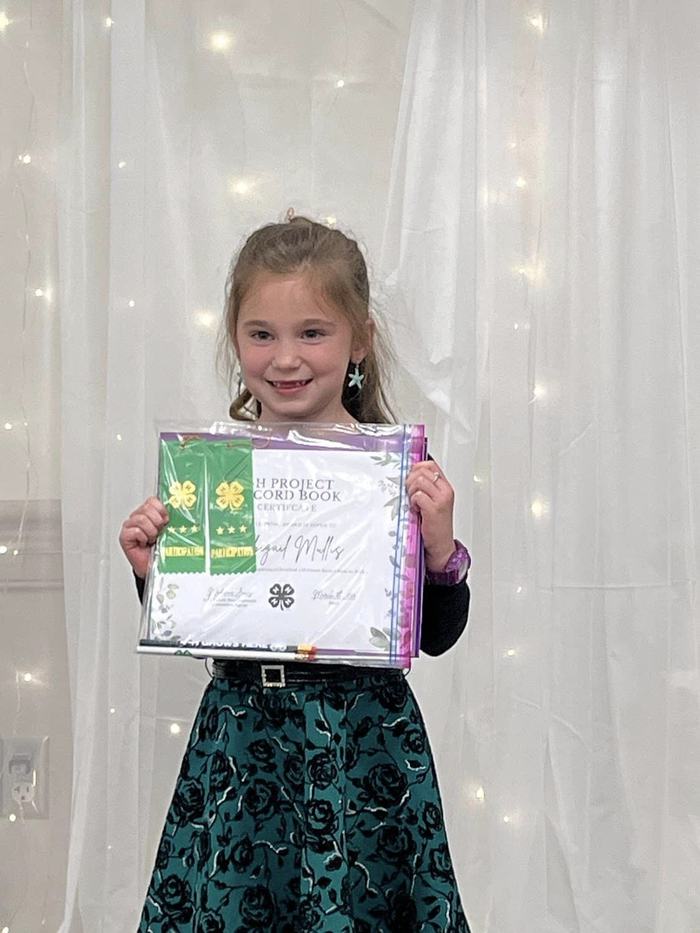 Abbigail Mullis receiving her award for submitting two Cloverbud Record Books