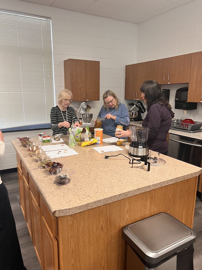 Three women work at a recipe.