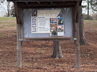 An outdoors bulletin board with information about bluebirds.
