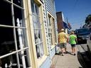 A couple walks on the sidewalk next to buildings downtown. 