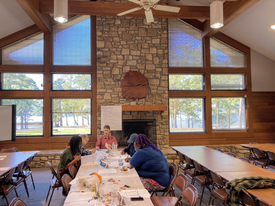 A Team of People Sitting Around a Table Writing on Paper
