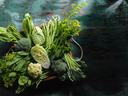 Market fresh green leaf vegetables in an old wooden crate on an old wooden turquoise table. Vegetables include, broccoli, cauliflower, cabbage, spring greens, bok choy, spinach and choy sum.
