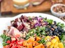 Kale salad with roasted sweet potato cubes, tomatoes, blueberries, beets, pecans