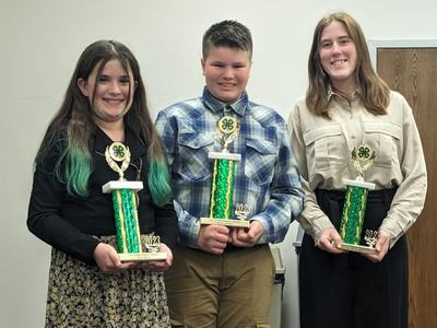 Three 4-h'ers posing with trophies.