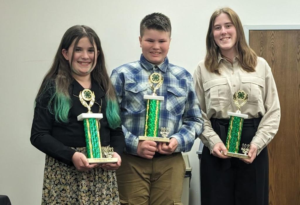 Three 4-h'ers posing with trophies.