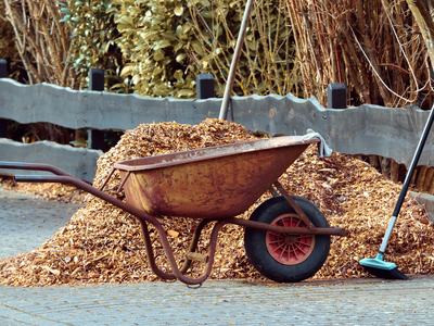 wheelbarrow garden tools and a wheelbarrow full of mulch.