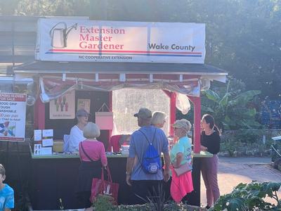 Extension Master Gardener Wake County booth with people at counter