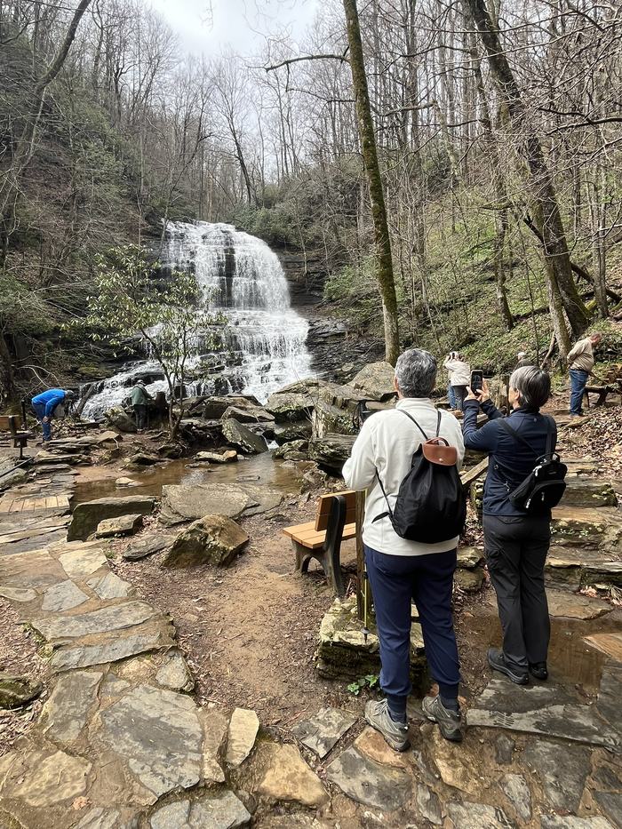 People look at a waterfall coming down the mountainside.