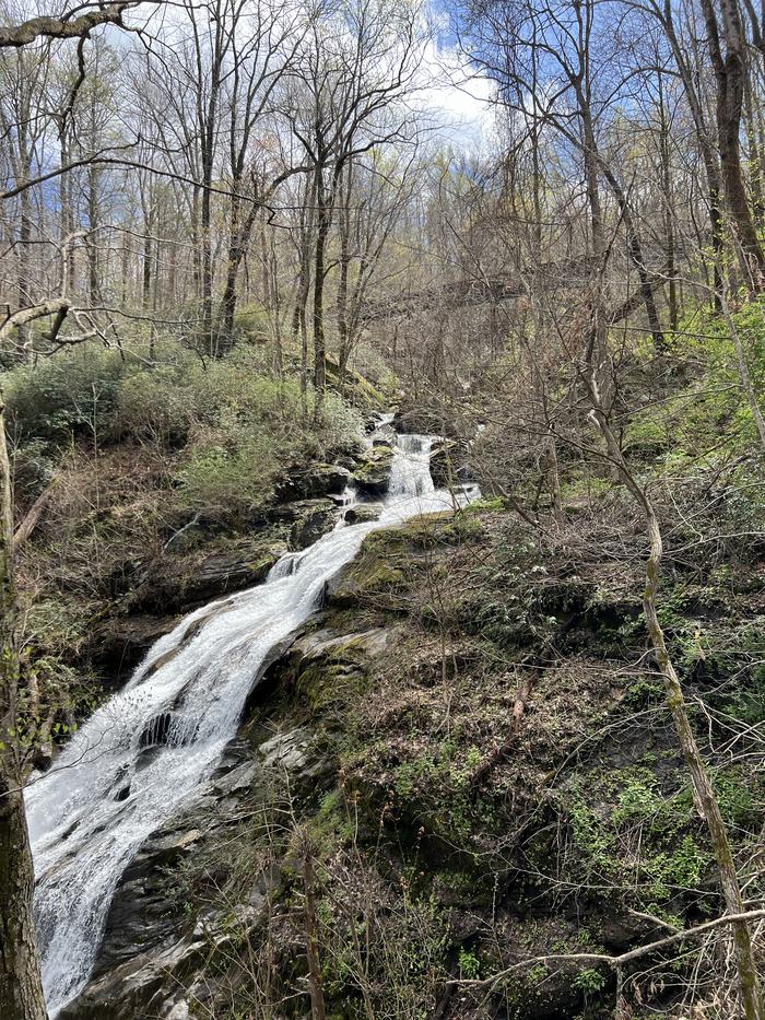 A long thin waterfall coming down the side of a mountain.