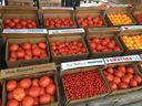 Crates of red and yellow tomatoes labeled "Vine Ripened TOMATOES"